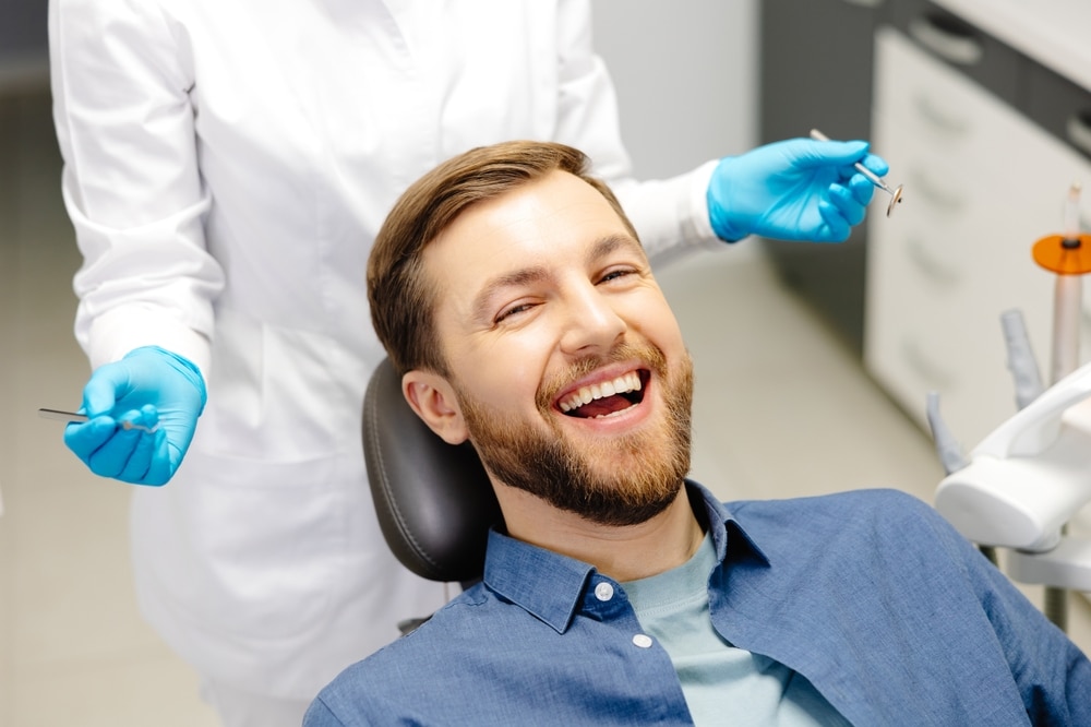 Portrait,Of,Happy,Man,Sitting,At,Dentist,Chair,In,Modern